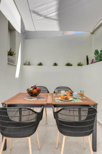 a dining room with a wooden table and chairs at Polis Suite in Ermoupoli