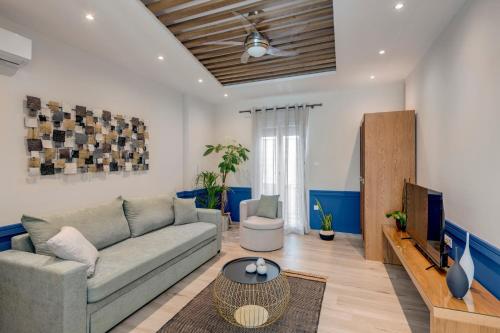 a living room with a couch and a tv at Polis Suite in Ermoupoli