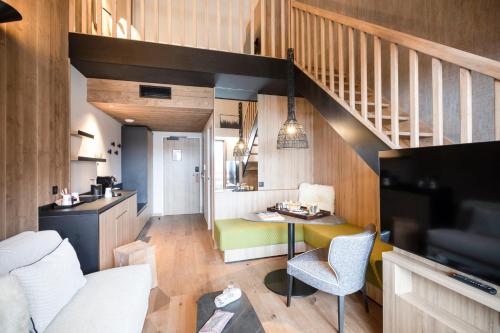a small living room with a table and a staircase at Novotel Megève Mont-Blanc in Megève
