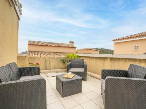 un patio avec des chaises et une table sur un balcon dans l'établissement Apartment L'Esquinade - H2 317 by Interhome, à Agay