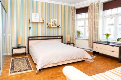 ein Schlafzimmer mit einem Bett und einer gestreiften Wand in der Unterkunft Suur-Sepa Residence in Pärnu