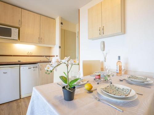 une cuisine avec une table avec un vase de fleurs dessus dans l'établissement Apartment L'Esquinade - E3 333 by Interhome, à Agay