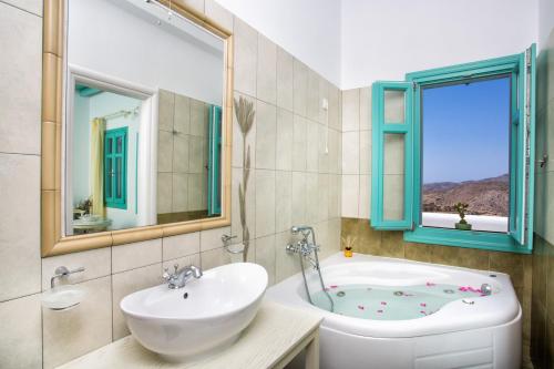 a bathroom with a tub and a sink and a toilet at Aria Boutique Hotel in Chora Folegandros