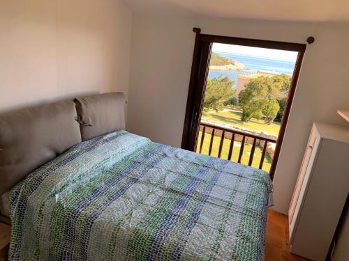 sypialnia z łóżkiem i dużym oknem w obiekcie GG Luxury Apartments - Porto Cervo - Costa Smeralda w mieście Porto Cervo