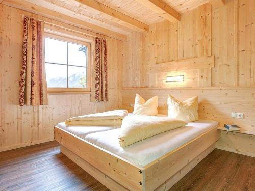 a bed in a wooden room with a window at Alois & Elisabeth, Chalet in Tux