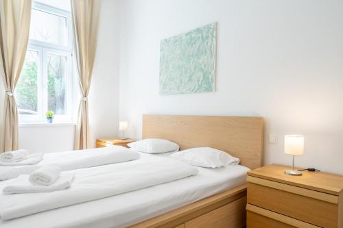 een slaapkamer met 2 bedden en een raam bij Cottageviertel - Stilvolles Apartment in Parknähe in Wenen