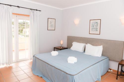 een slaapkamer met een blauw bed met 2 witte kussens bij Casa Louisa in Casal da Lagoa Seca
