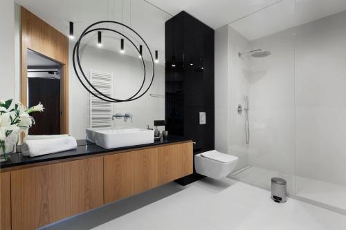 a bathroom with a sink and a mirror at Elite Apartments Tarasy Bałtyku in Gdańsk