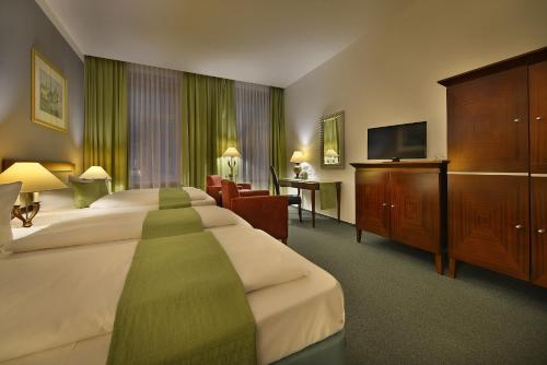 プラハにあるPrague Season Three Starsのベッド2台、薄型テレビが備わるホテルルームです。