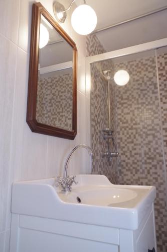 a bathroom with a white sink and a mirror at Domaine de Peyreguilhot in Laparade
