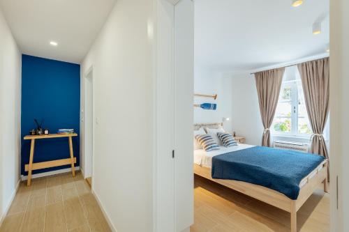 a bedroom with a bed with blue sheets and a window at Magnolia Apartments 1 Herceg Novi in Herceg-Novi
