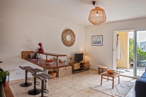 un salon avec une table et une télévision dans l'établissement Appartement Casa Linda avec jardin 900m de la plage et du centre ville, à Calvi