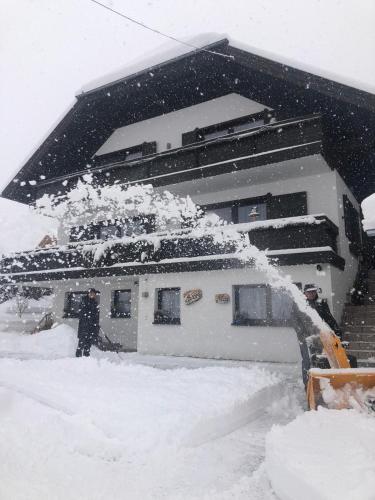 a person is spraying snow off of a house at Haus Greet in Muhr