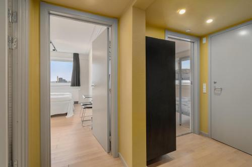 a room with yellow walls and a hallway with doors at Danhostel Copenhagen City & Apartments in Copenhagen