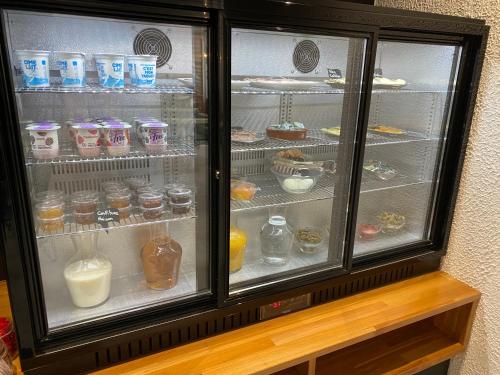 a refrigerator filled with lots of different types of drinks at Hôtel Les Sables - Urban Style - by Logis Hotels in Canet-en-Roussillon