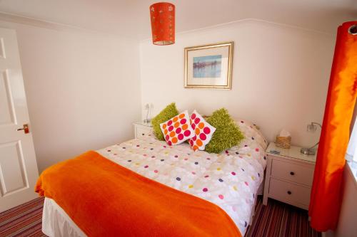 a small bedroom with a bed with polka dot pillows at Krissie's in Marazion