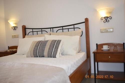 a bedroom with a bed with white sheets and pillows at Asterias Studios in Agia Anna Naxos