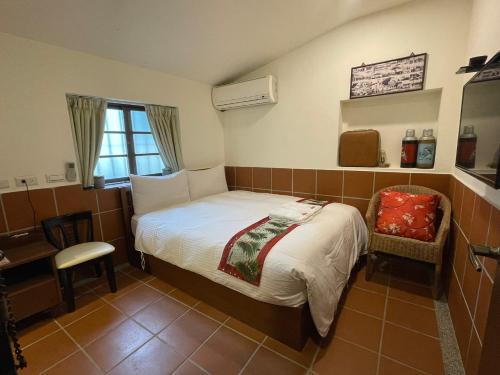 - une petite chambre avec un lit et une chaise dans l'établissement 左營蓮潭郭家百年古厝, à Kaohsiung