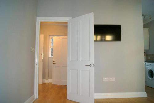 a white door in a room with a laundry room at Victorian Building With Character in London