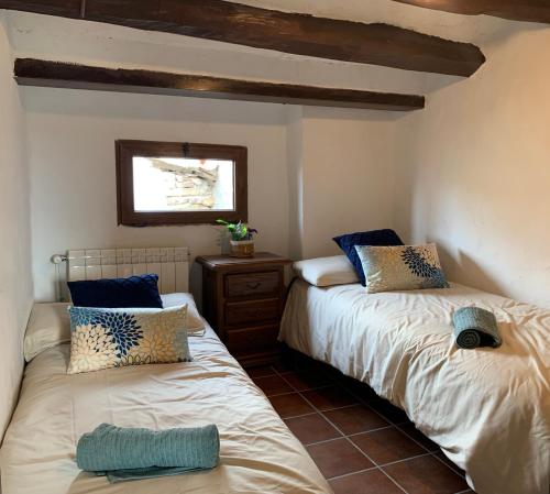 dos camas sentadas una al lado de la otra en una habitación en Vive la vida rural: Alojamiento en Les Piles. NIU RURAL, S.L., en Las Pilas