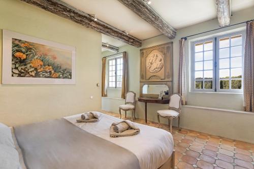 a bedroom with a bed and a desk and windows at Pavillon Lou in Crillon-le-Brave