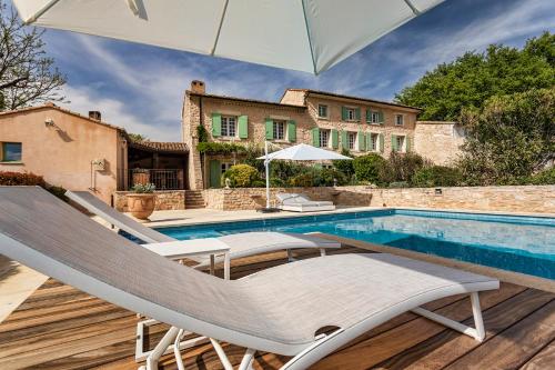 une piscine avec deux chaises longues et un parasol dans l'établissement Pavillon Lou, à Crillon-le-Brave
