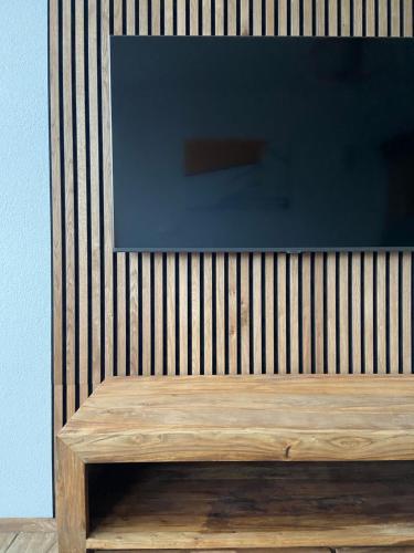 a television sitting on top of a wooden bench at Das Stubai - exklusiv, einzigartig & nachhaltig in Fulpmes