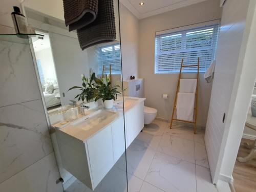 a bathroom with a sink and a tub and a toilet at Knysna Private Estate Lagoon Apartment - Garden Apartment - Secure Estate in Knysna
