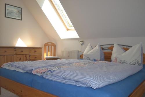 a bedroom with a bed with a blue comforter at Haus Simone in Insel Poel