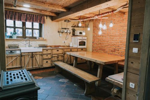 a kitchen with a wooden table and a brick wall at Hostel Lukna in Mojstrana
