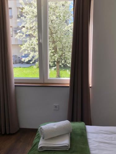 a bedroom with a window with towels on a bed at Apartments Zafira in Ohrid