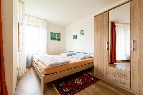 1 dormitorio con 1 cama y puerta de madera en Ferienwohnpark Immenstaad am Bodensee Ein-Zimmer-Apartment 53 19 en Immenstaad am Bodensee