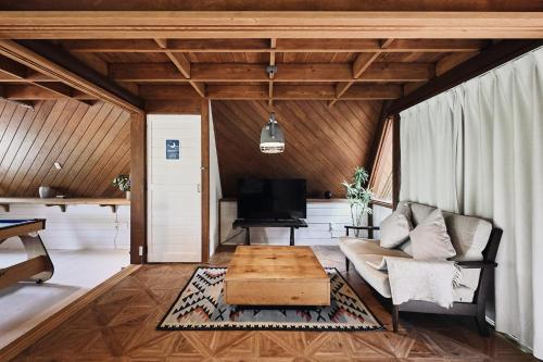 a living room with a couch and a table at LOGIN OKlNAWA -counrty- in Onna
