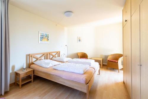 - une chambre avec un lit et des oreillers blancs dans l'établissement Ferienwohnpark Immenstaad am Bodensee Zwei-Zimmer-Apartment 51 13, à Immenstaad am Bodensee