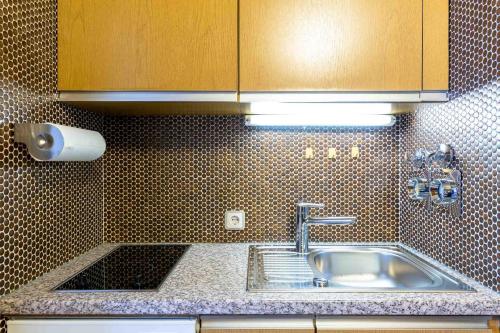 a kitchen with a sink and a counter top at Ferienwohnpark Immenstaad am Bodensee Ein-Zimmer-Apartment 49 41 in Immenstaad am Bodensee