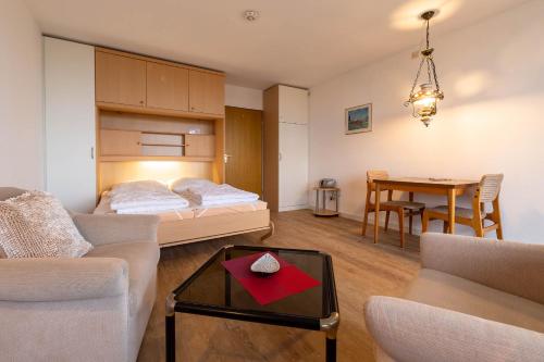 un soggiorno con letto e tavolo di Ferienwohnpark Immenstaad am Bodensee Ein-Zimmer-Apartment 49 31 a Immenstaad am Bodensee