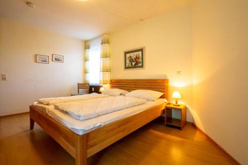 een slaapkamer met een groot bed in een kamer bij Ferienwohnpark Immenstaad am Bodensee Zwei-Zimmer-Apartment 53 01 in Immenstaad am Bodensee