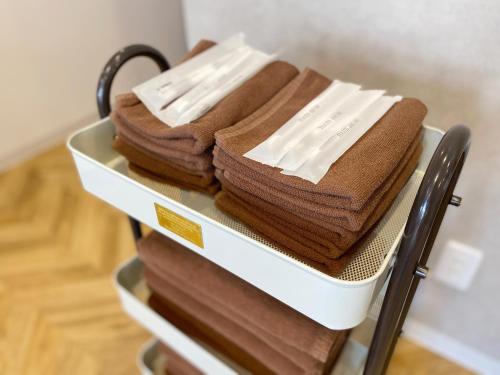 a rack of towels sitting on top of a towel rack at TABISAI HOTEL Terrace 博多 in Fukuoka