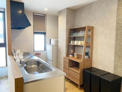 a kitchen with a sink and a refrigerator at TABISAI HOTEL Terrace 博多 in Fukuoka