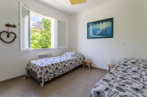 1 dormitorio con cama y ventana en Petit Paradis Garrigue, en Moulézan