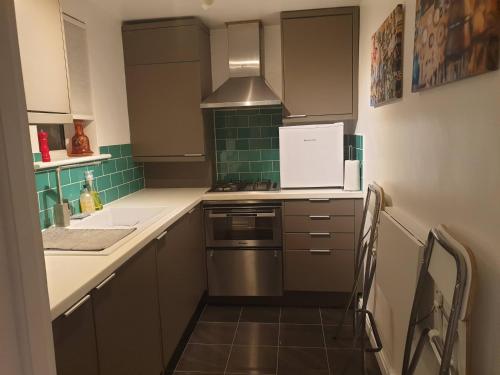 a kitchen with a sink and a stove top oven at Cozy Muswell Hill 1-Bedroom Flat in London