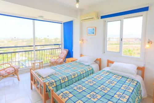 a bedroom with two beds and a balcony at Villa Aphrodite Finiki in Polis Chrysochous