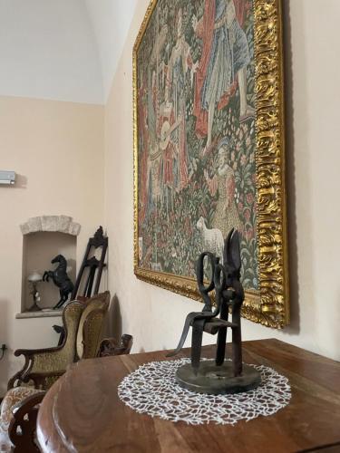 een tafel met een schilderij aan de muur en een standbeeld bij Palazzo Morola XIV century in Giovinazzo