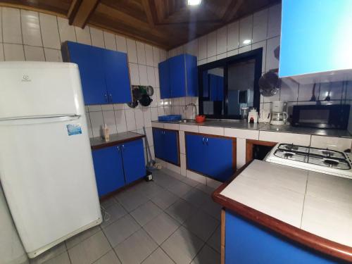 a kitchen with blue cabinets and a white refrigerator at LAUNAPARK RESIDENCE in Douala