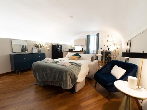 - une chambre avec un grand lit et une chaise bleue dans l'établissement The Best Rent - Apartment near Piazza di Spagna, à Rome