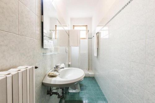 a white bathroom with a sink and a mirror at Hotel Guerrini in Venice