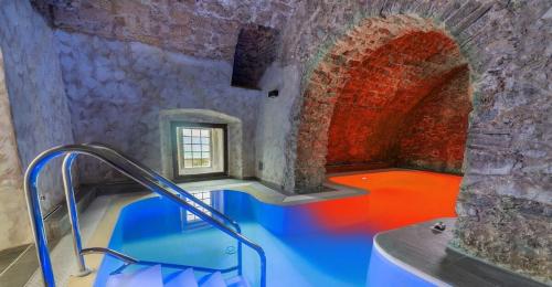 uma casa de banho com uma grande banheira azul num edifício em Palazzo Cestari Hotel em Montesano sulla Marcellana