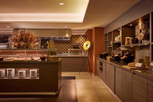 a large kitchen with a counter with aperature at Van der Valk Hotel Dennenhof in Brasschaat