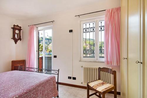 a bedroom with a bed and a chair and windows at Maremonti in Casarza Ligure