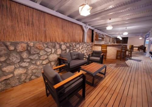 a lobby with chairs and a stone wall at Vista Del Amor Faralya in Fethiye